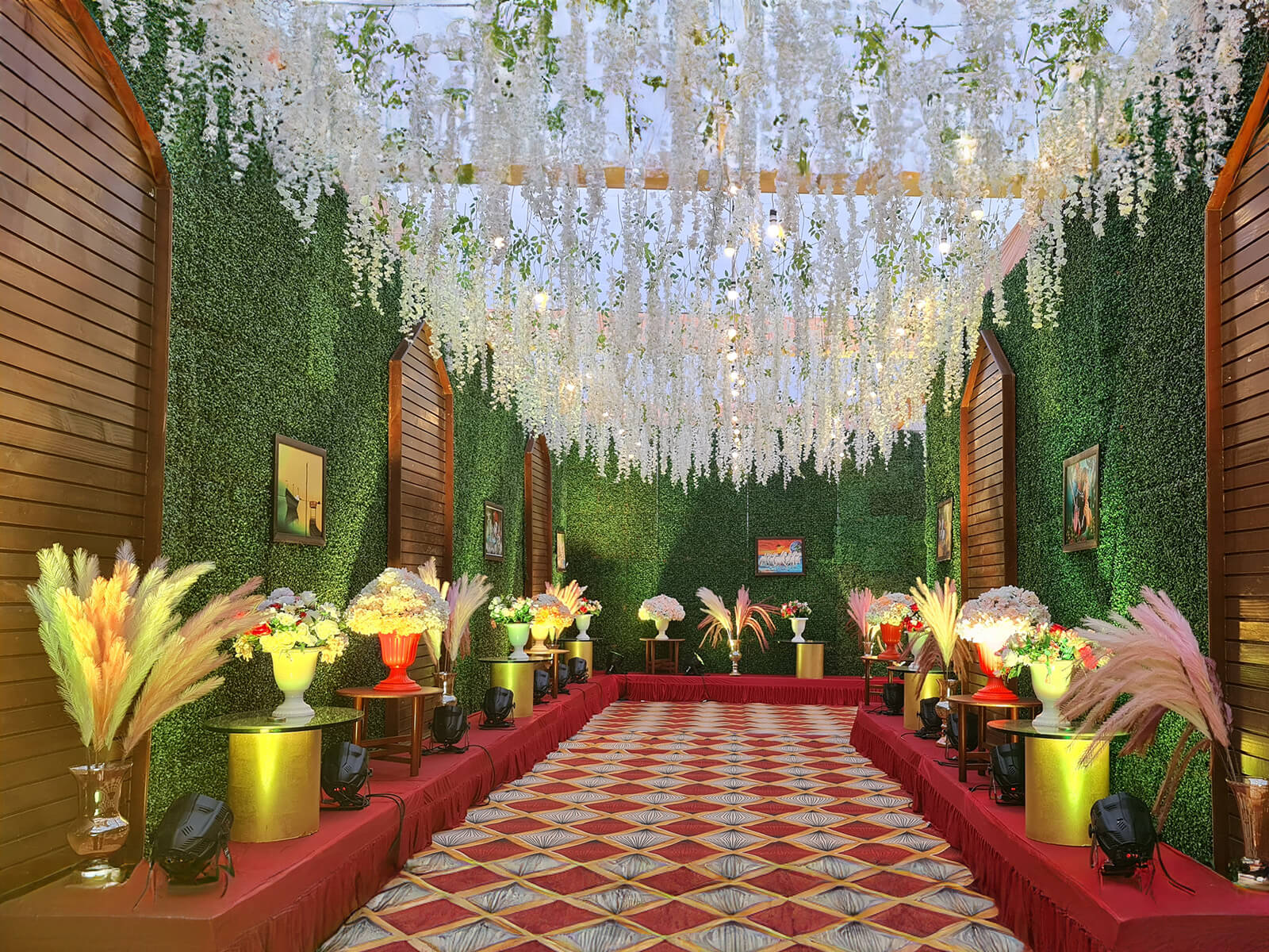 Indoor event space with elegant floral decorations and hanging lights, ideal for special occasions and celebrations.