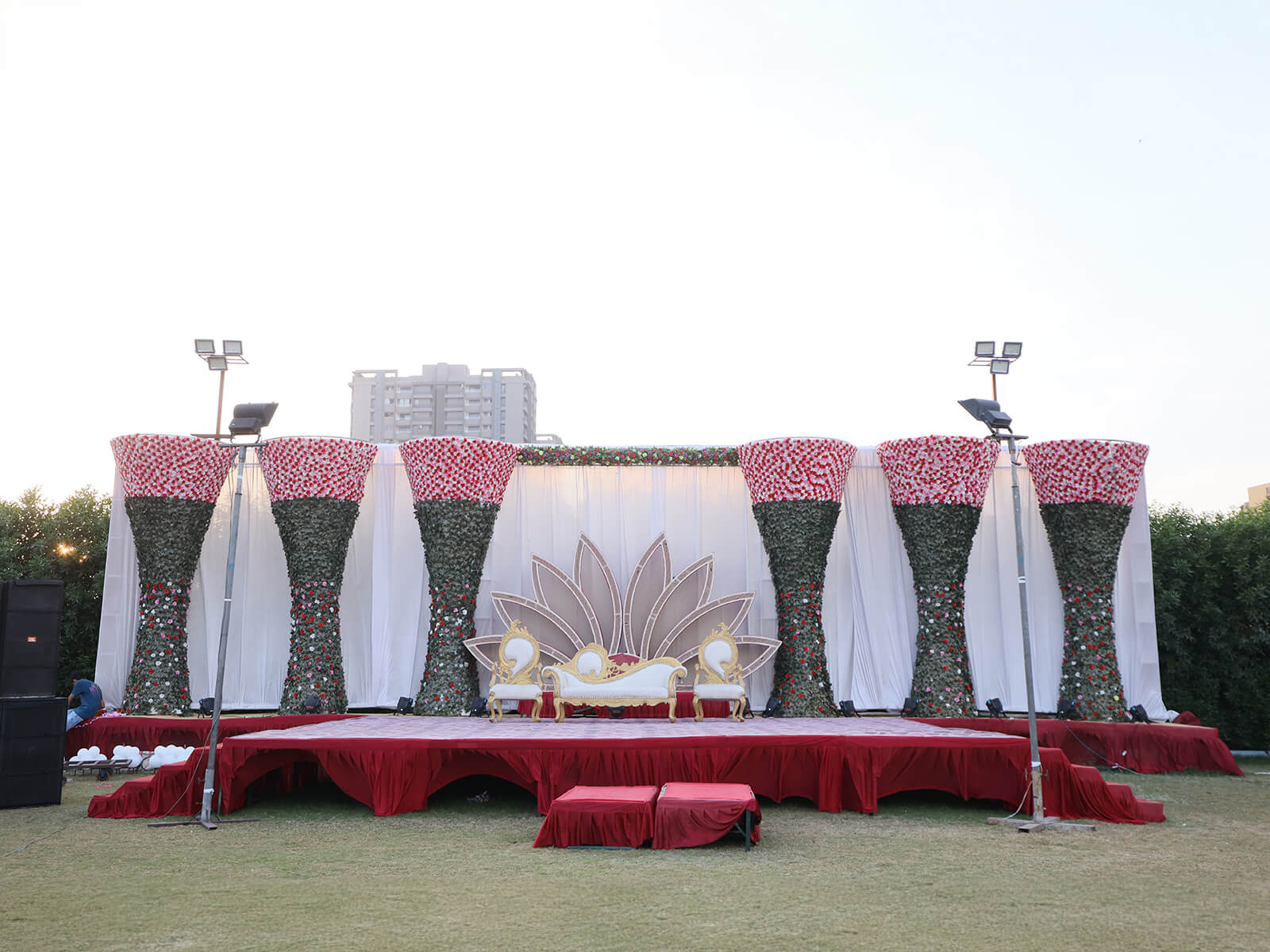 Decorated wedding stage with elegant floral arrangements and seating, designed for outdoor ceremonies and special events.