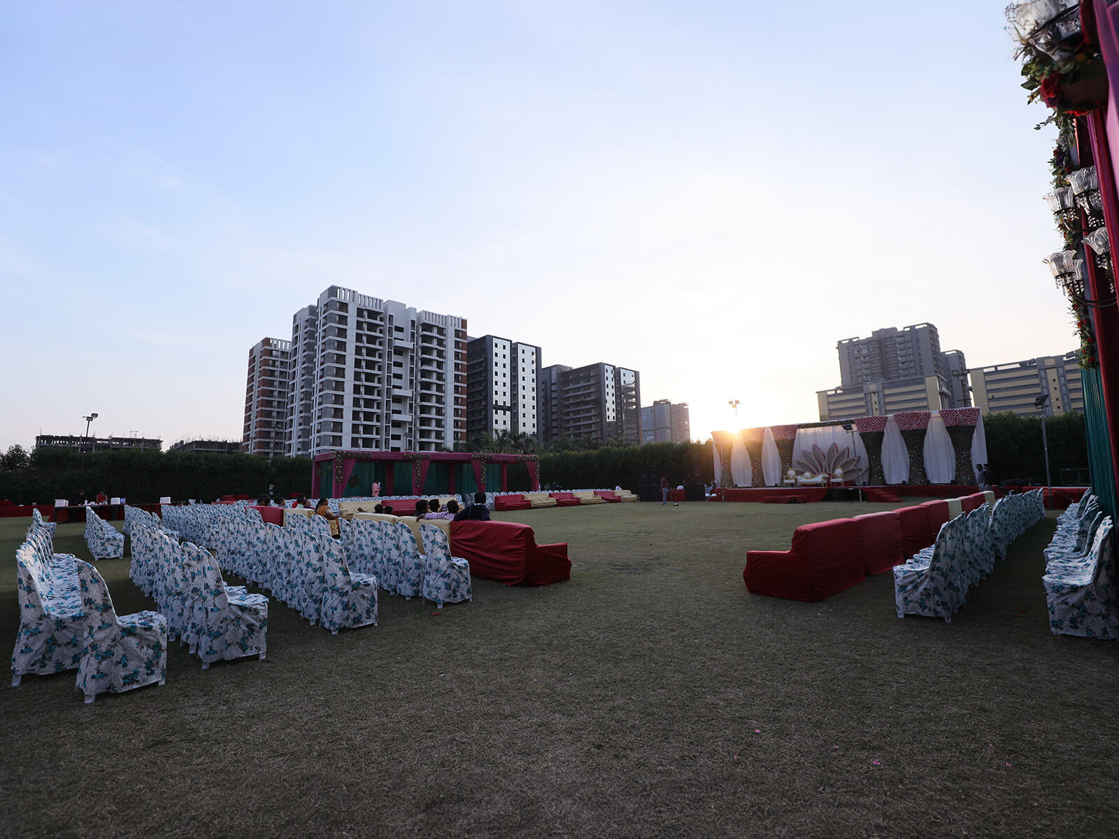 Outdoor wedding venue with covered seating and stage setup, ideal for large ceremonies and special celebrations.