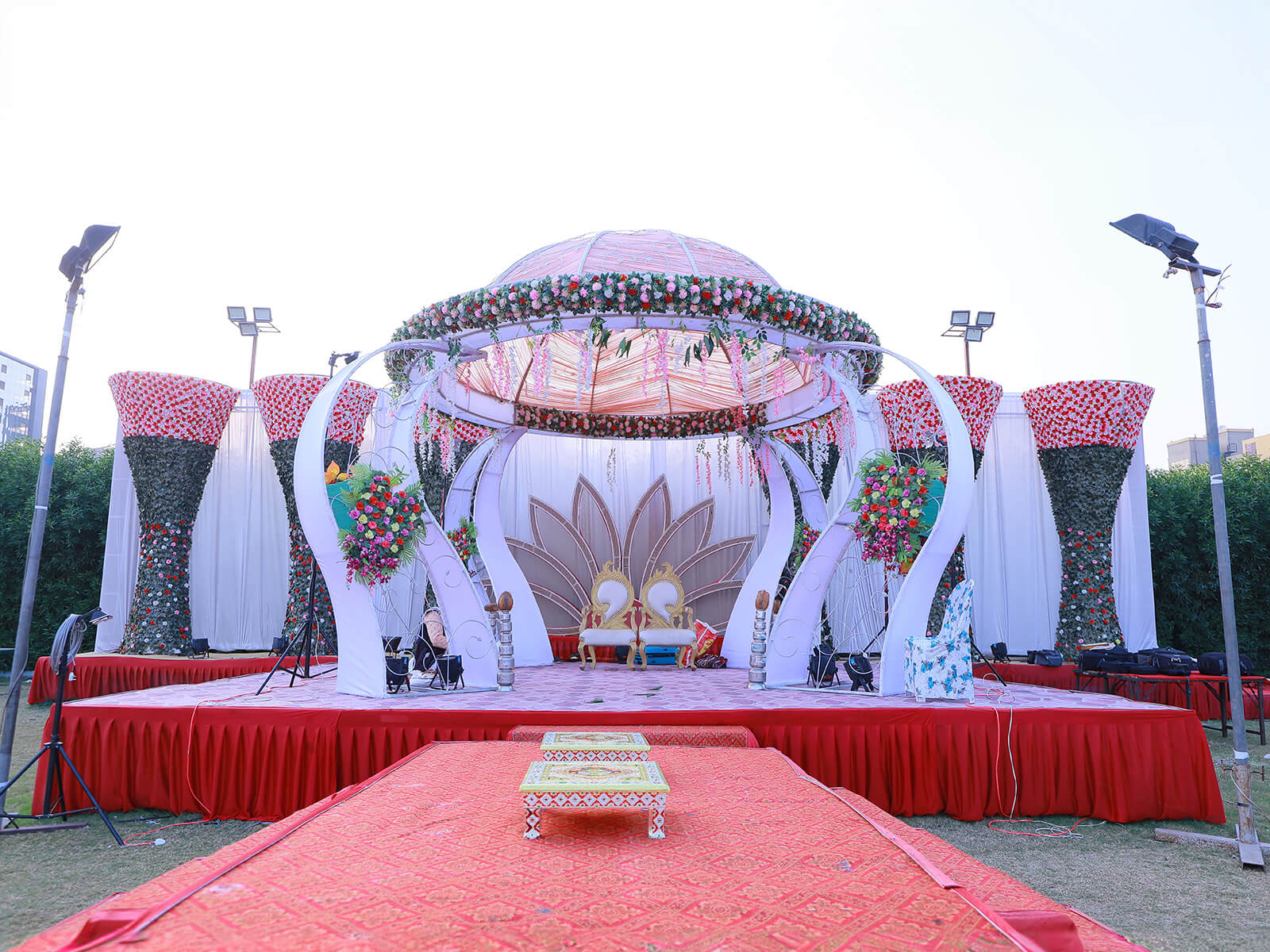 Outdoor wedding stage with elaborate floral decorations and elegant canopy, perfect for grand wedding ceremonies and special celebrations.