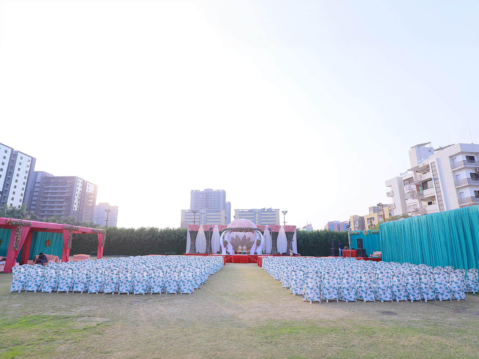 Outdoor wedding ceremony setup with decorated seating and a central stage, ideal for large gatherings and special celebrations.