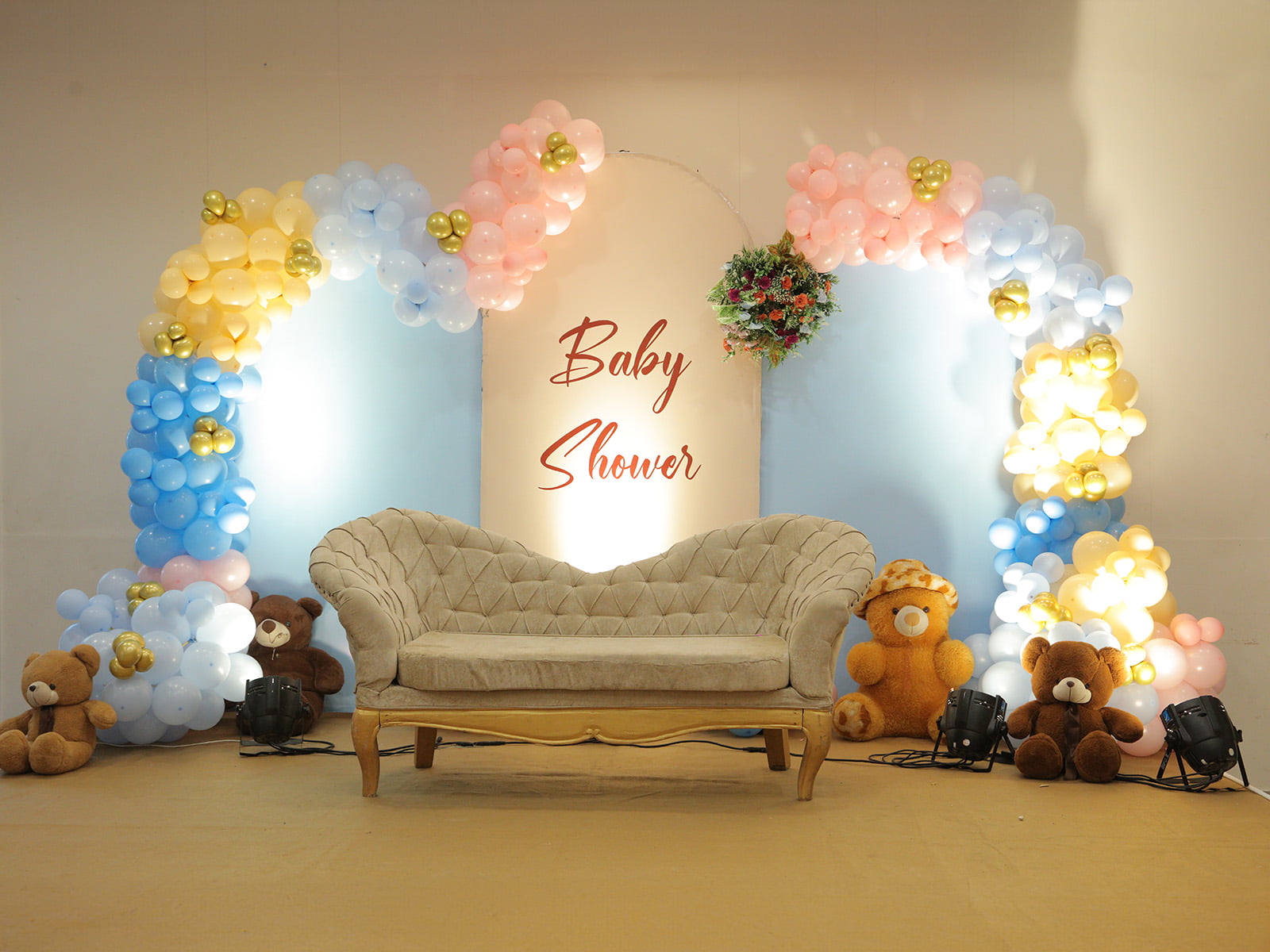 Indoor baby shower decoration with floral arrangements and pastel balloons