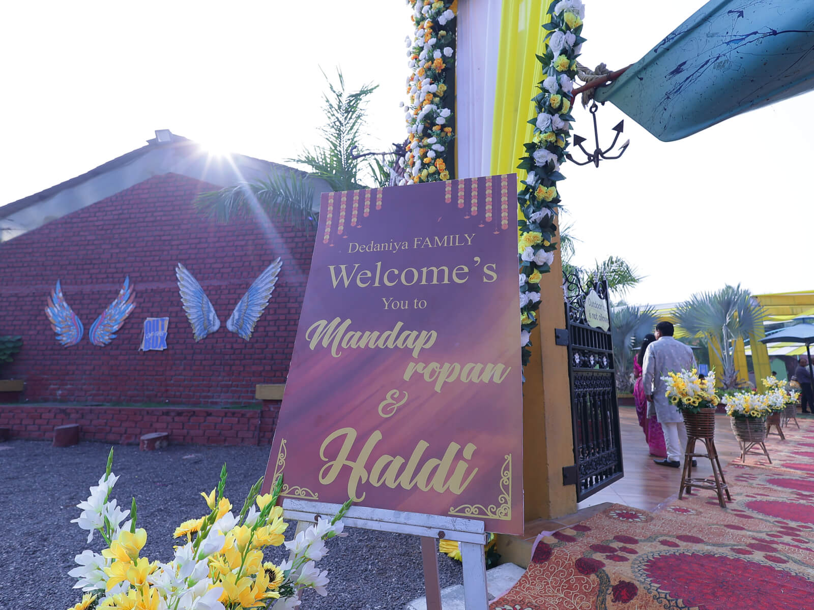 Outdoor Haldi event decoration with bright yellow drapes, floral arrangements, and traditional elements, perfect for wedding celebrations and event planning.