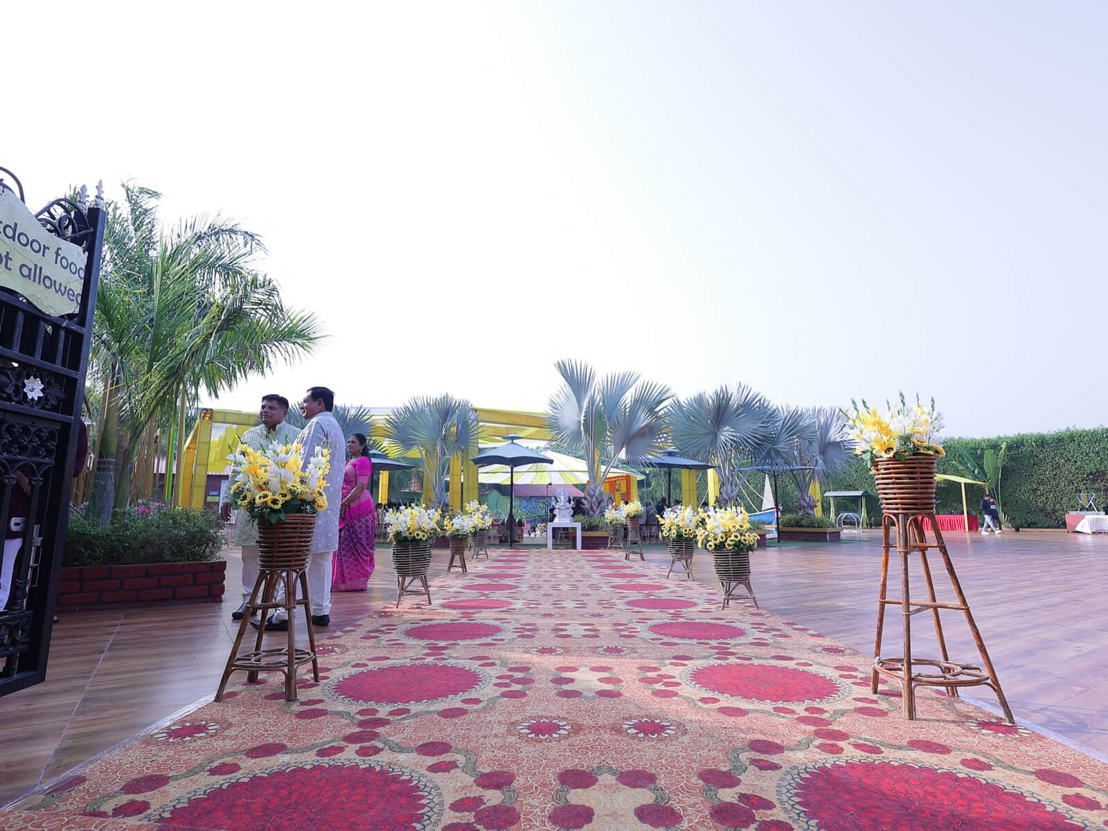 Outdoor Haldi event decoration with colorful drapes, vibrant floral arrangements, and traditional elements, ideal for wedding celebrations and event planning.