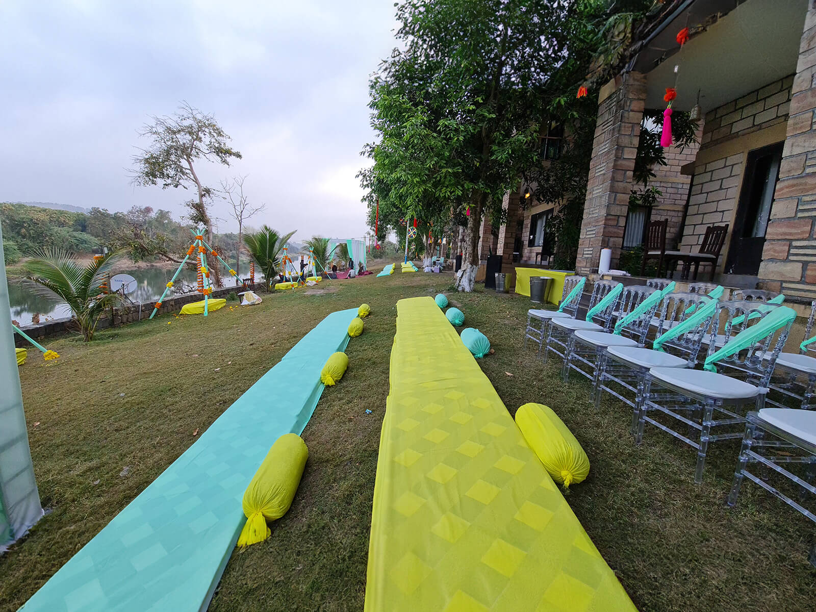 Outdoor haldi ceremony setup with colorful cushions and traditional decorations.