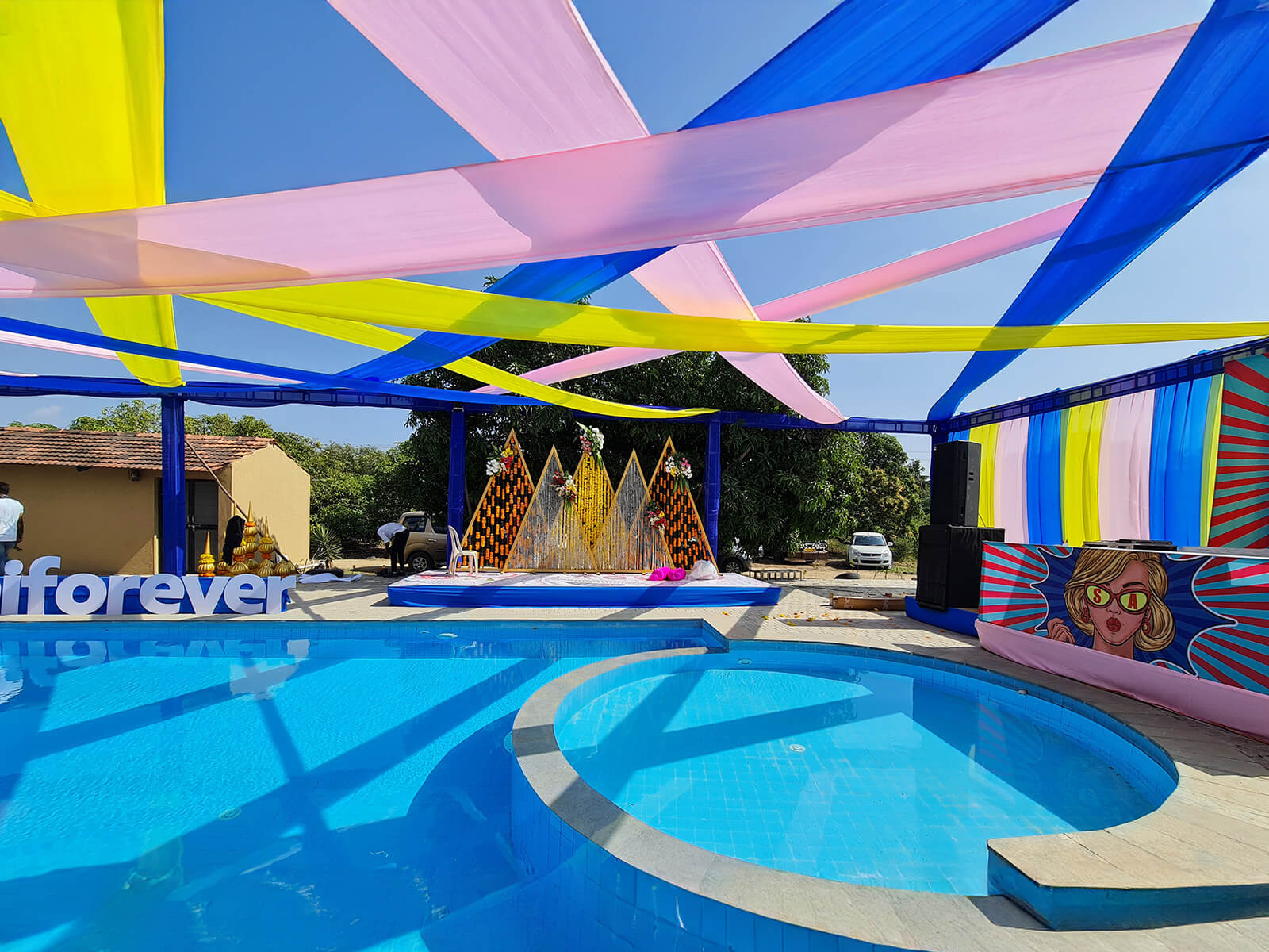 Outdoor event setup with colorful drapes and poolside arrangement, ideal for vibrant celebrations and special events.