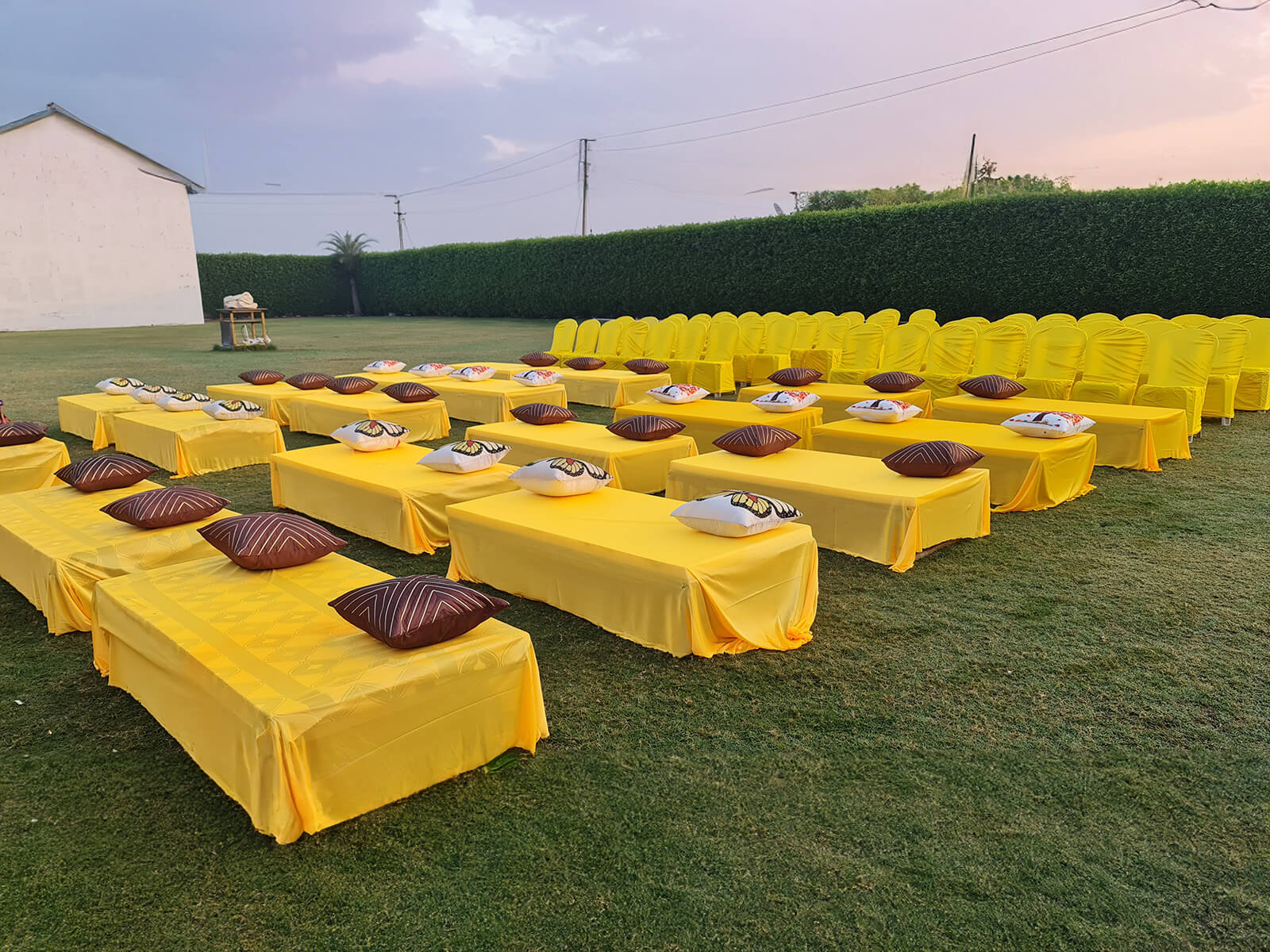 Outdoor haldi ceremony setup with yellow decorations and seating arrangement, ideal for event planning, wedding decoration, and destination weddings.