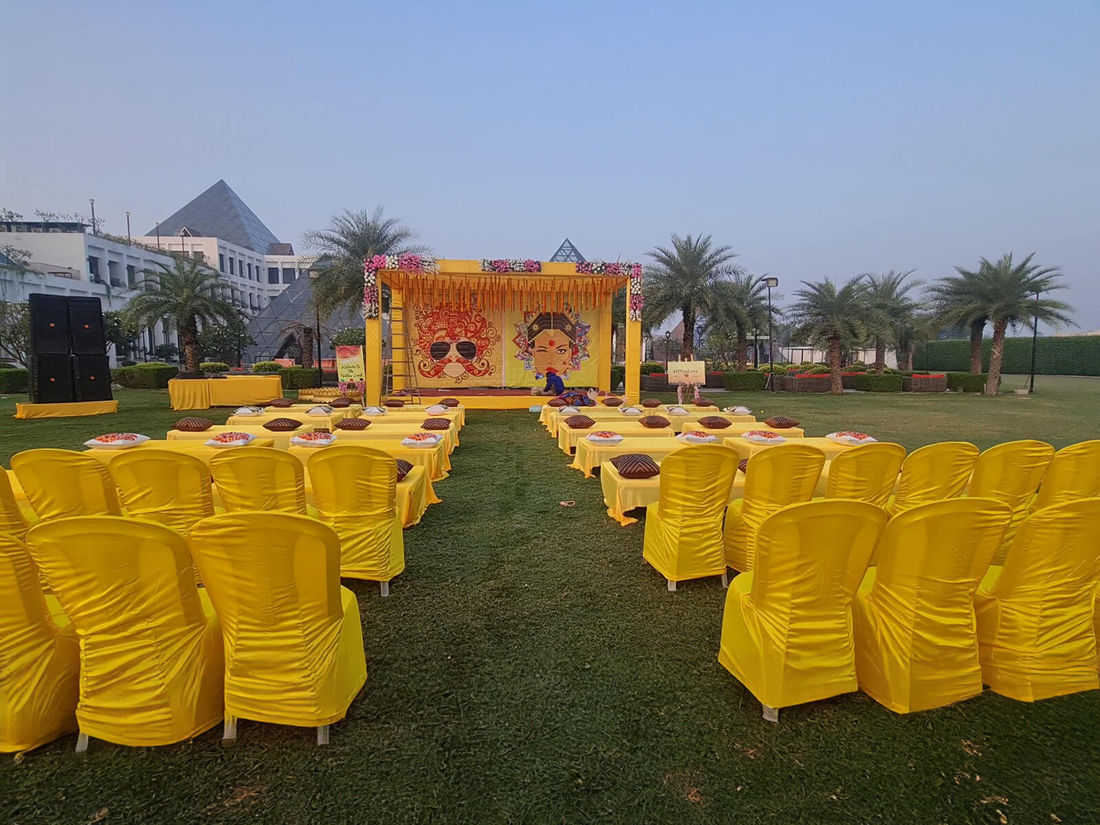 Outdoor haldi ceremony setup with yellow decorations and seating arrangement, ideal for event planning, wedding decoration, and destination weddings.