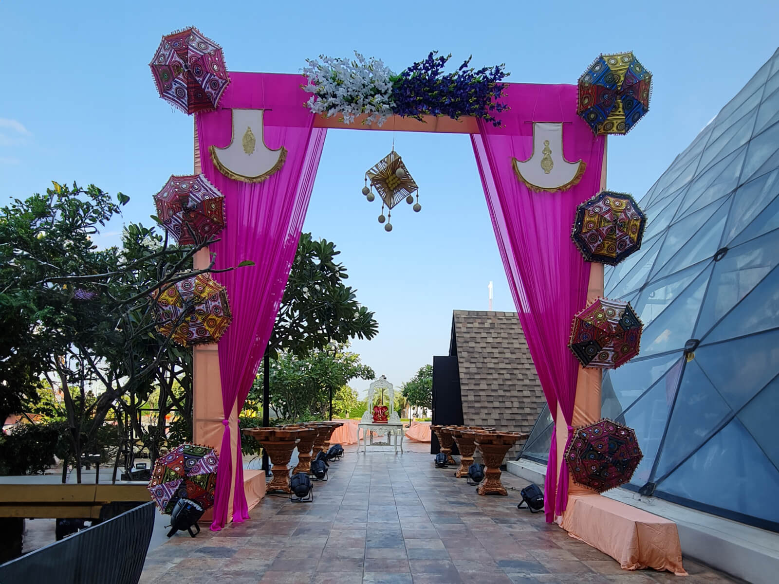 Outdoor mehndi event with floral decorations and colorful drapes