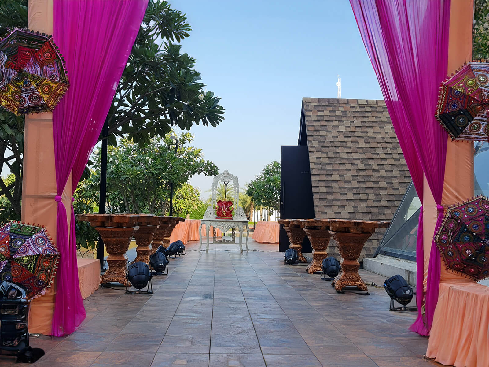 Outdoor mehndi event with traditional decor and colorful seating arrangements