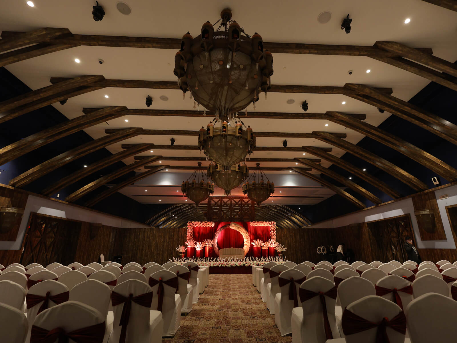 Indoor wedding event hall with elegant seating arrangement and stage setup, perfect for wedding decoration, event planning, and sangeet ceremonies.