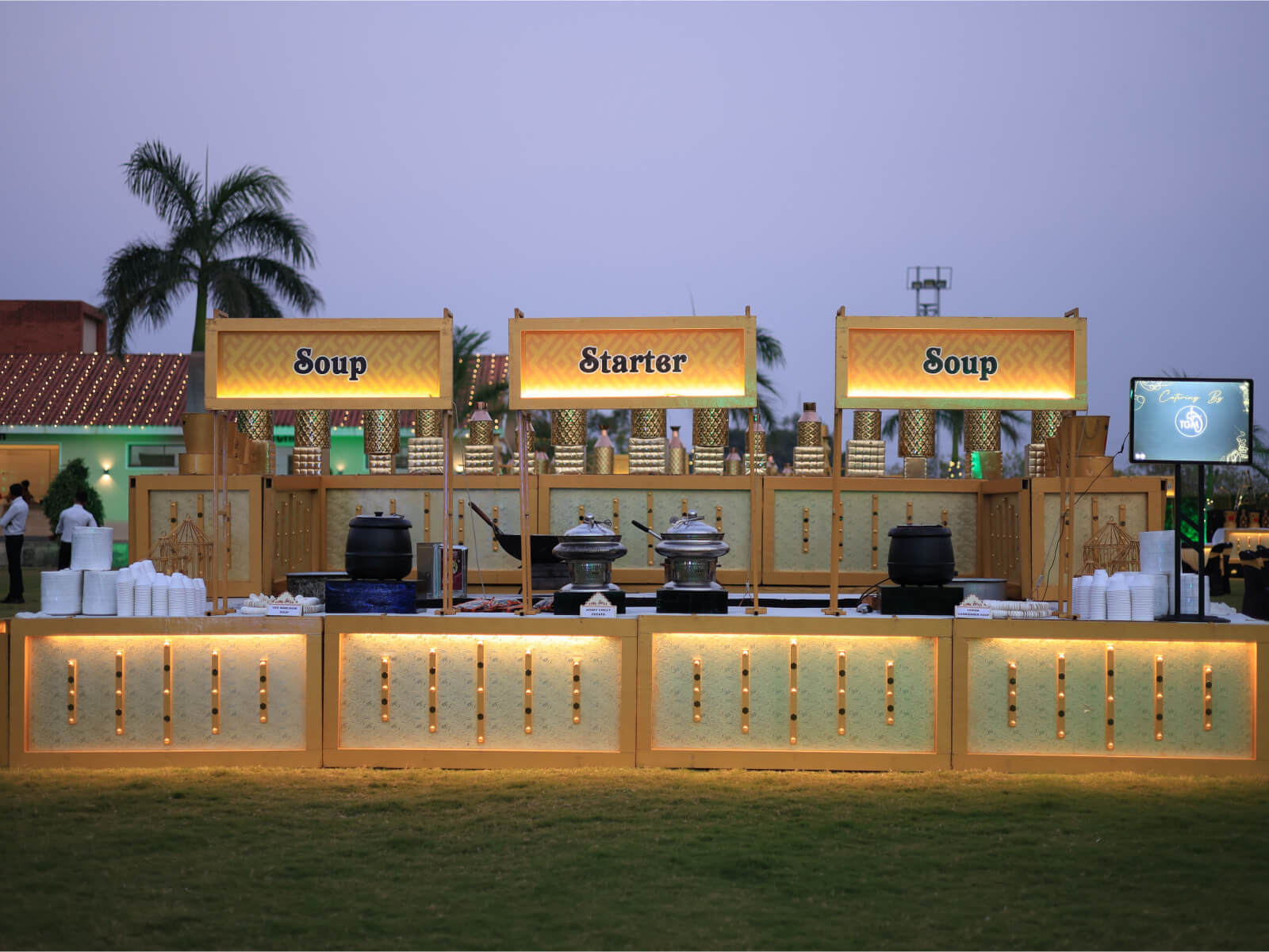 Outdoor wedding food stall setup with soup and starter counters.