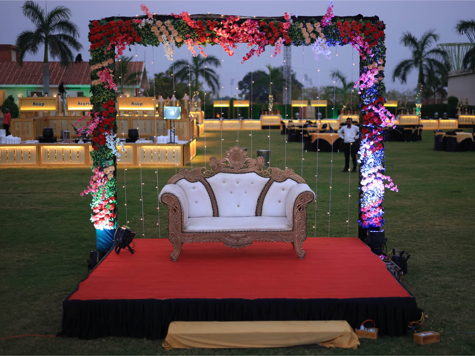 Outdoor wedding seating area with floral arch and elegant decor.