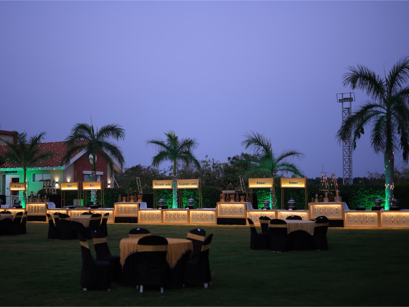 Outdoor wedding food court with multiple cuisine counters and elegant seating arrangements.