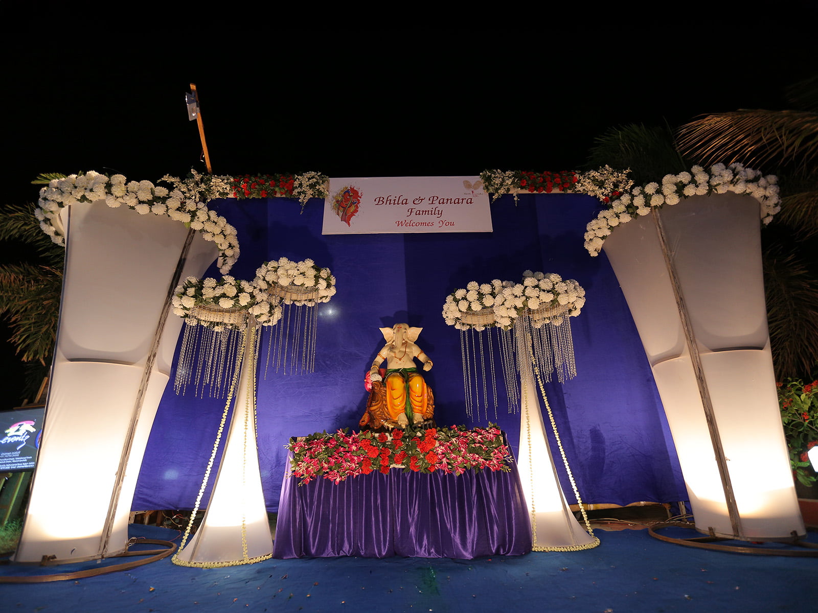 Indoor event stage with Ganesha idol and floral decorations, ideal for wedding decoration, event planning, and religious ceremonies.