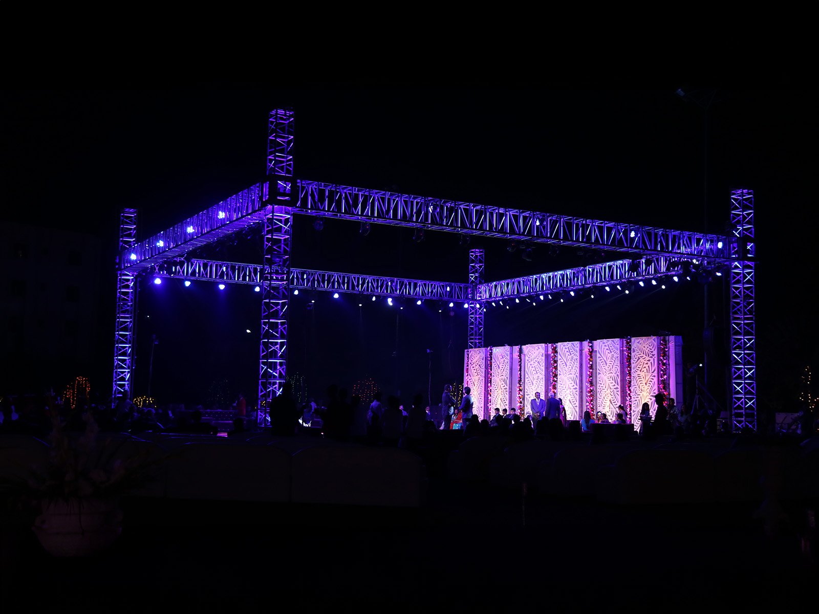 Outdoor event stage setup with musical instruments and illuminated backdrop, ideal for sangeet ceremonies, event planning, and wedding decoration.