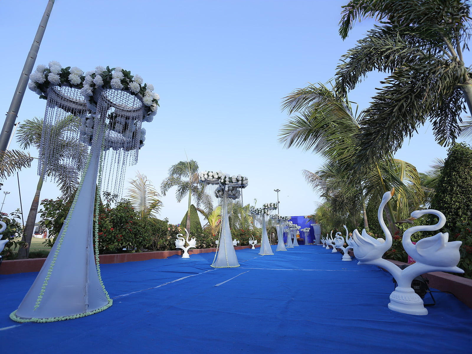 Outdoor wedding event with elegant floral decorations and swan sculptures, ideal for wedding decoration, event planning, and destination weddings.