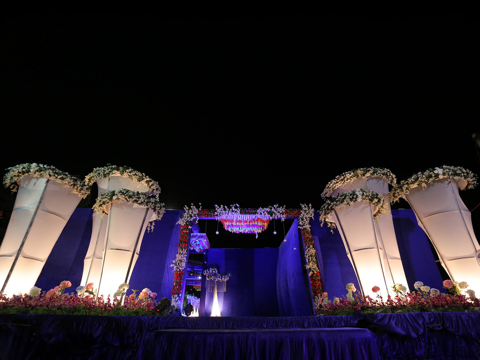 Outdoor wedding event with elegant floral decorations and swan sculptures, ideal for wedding decoration, event planning, and destination weddings.