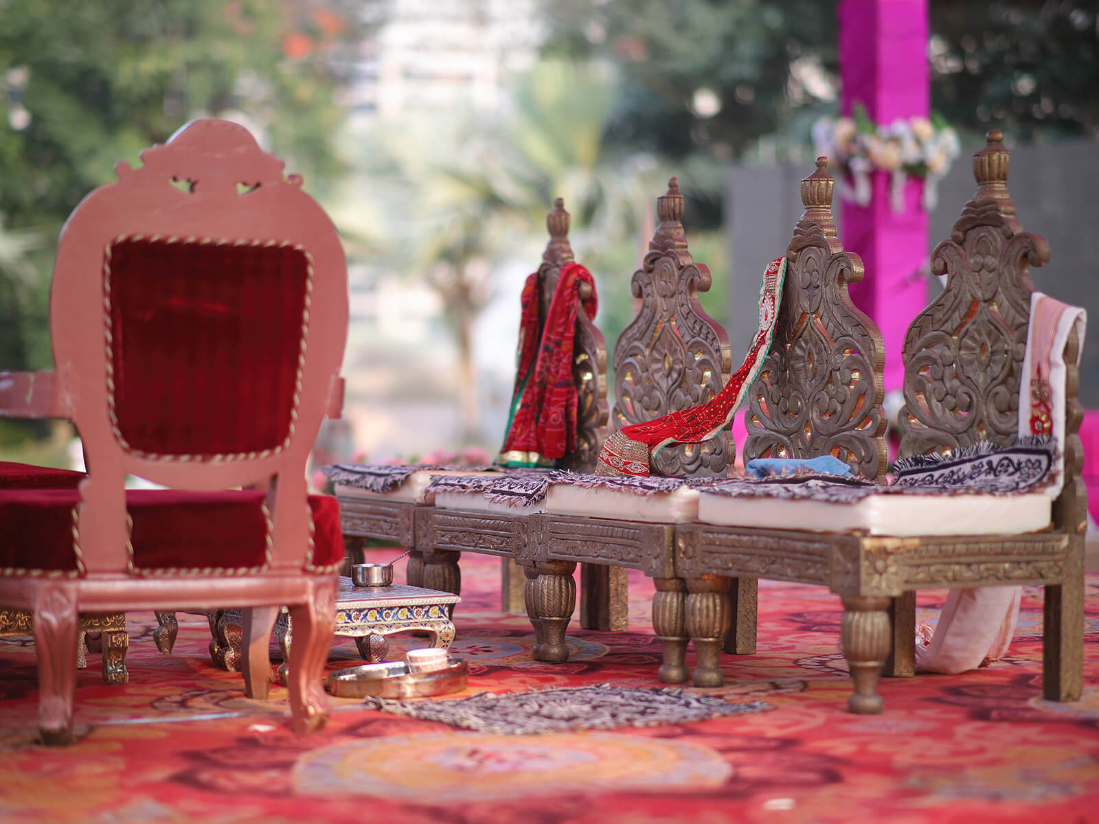 Outdoor wedding mandap setup with traditional chairs and ceremonial decorations.