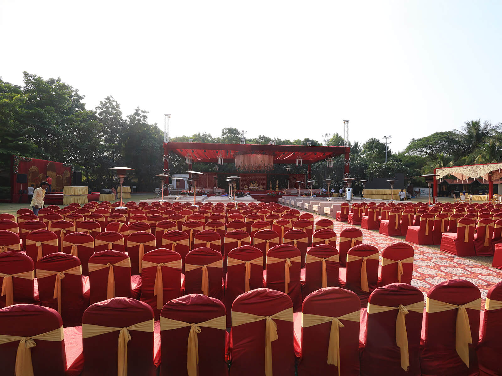 Outdoor wedding decoration with elegant floral arrangements, golden arches, and intricate canopy design, perfect for destination weddings and event planning.