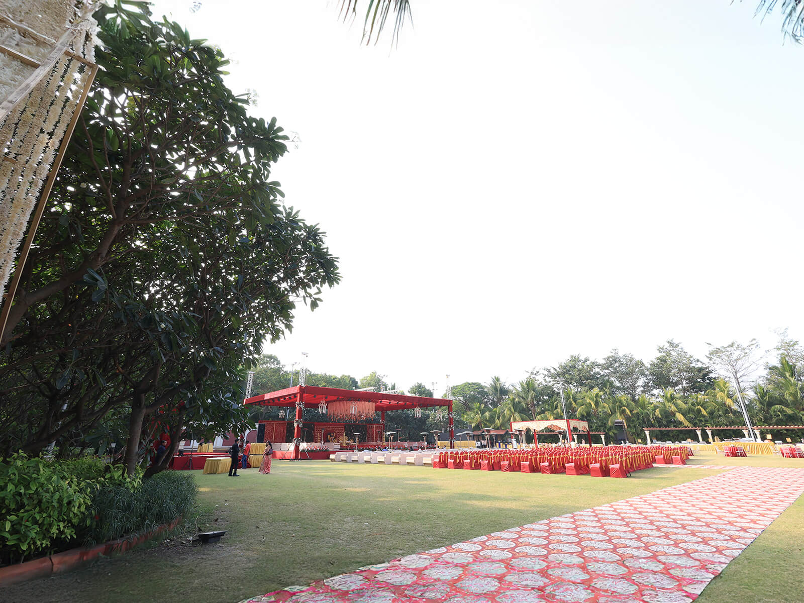 Outdoor wedding decoration with golden geometric panels, floral arrangements, and intricate canopy design, perfect for event planning and destination weddings.