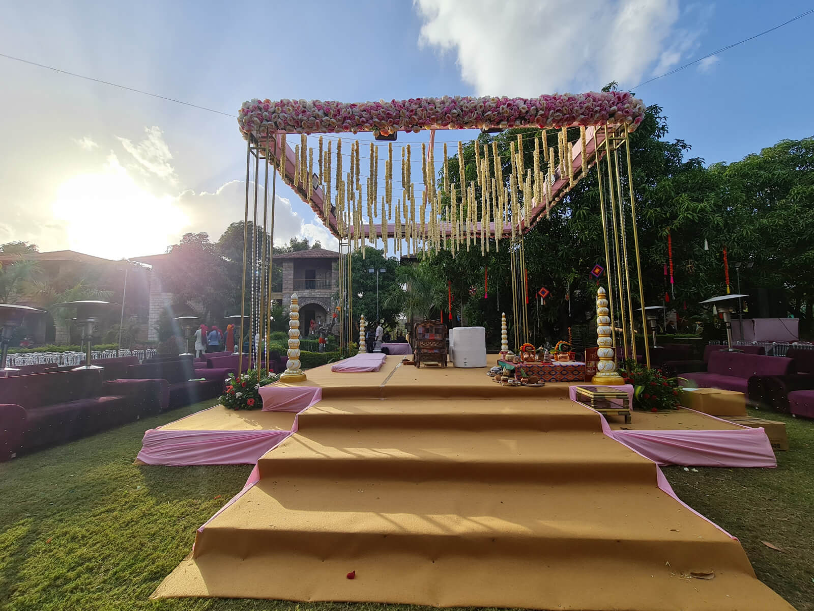 Outdoor wedding stage with elegant floral decorations and traditional elements, creating a beautiful setting for ceremonies and celebrations under the open sky.